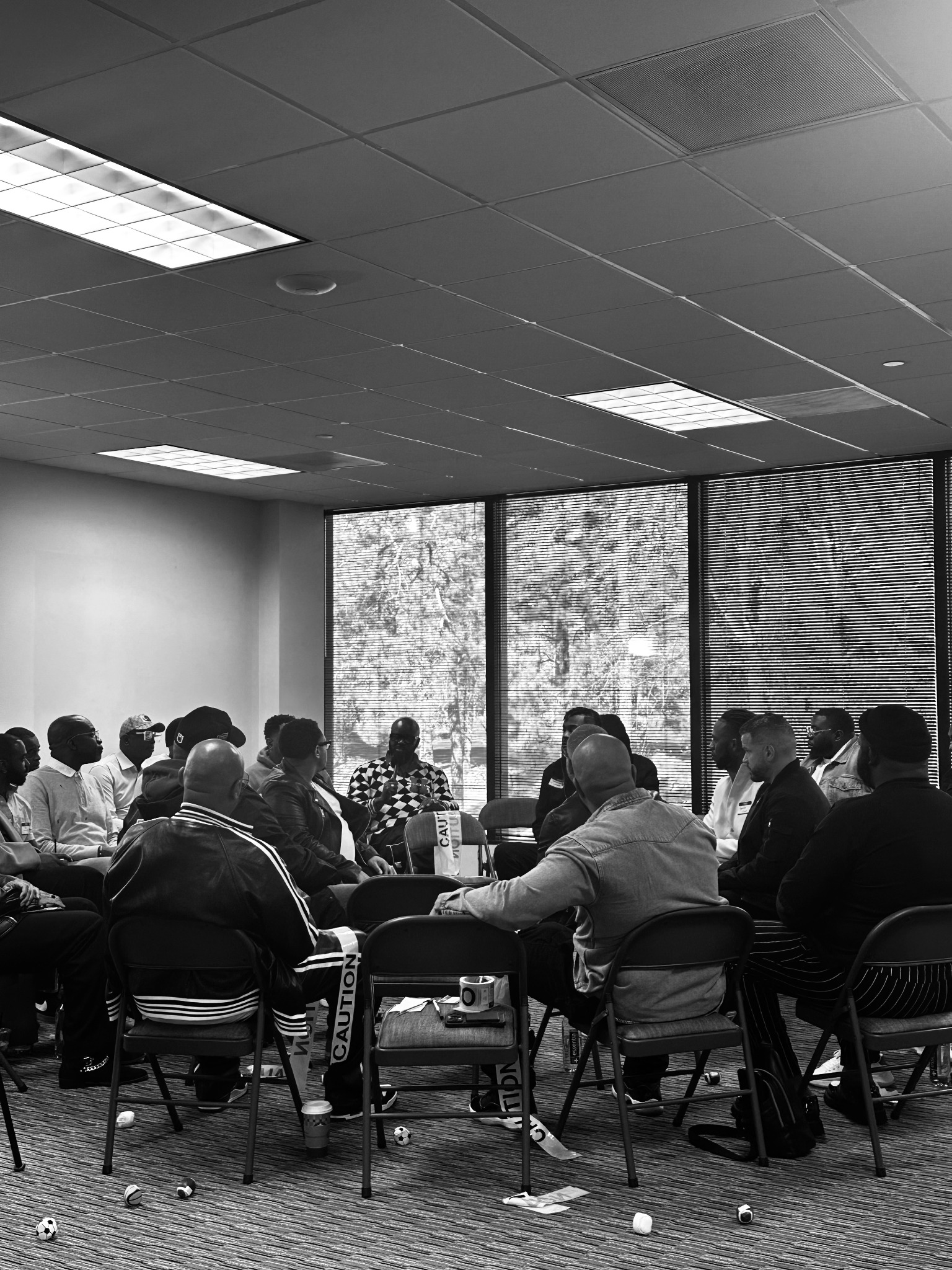 A circle of men engaged in a guided healing conversation