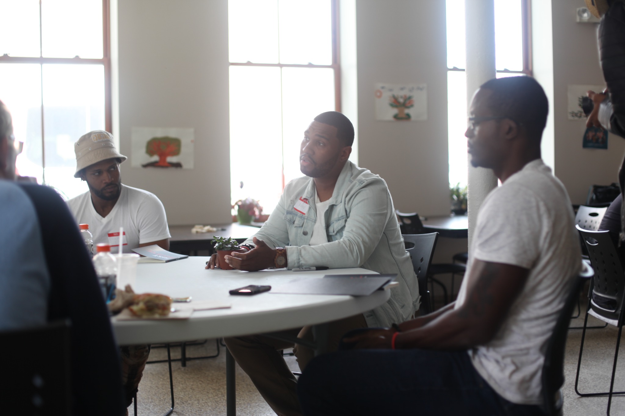 Men gathered around a table in conversation